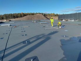 Arbeidere taktekker foter/fester for solcellepanel